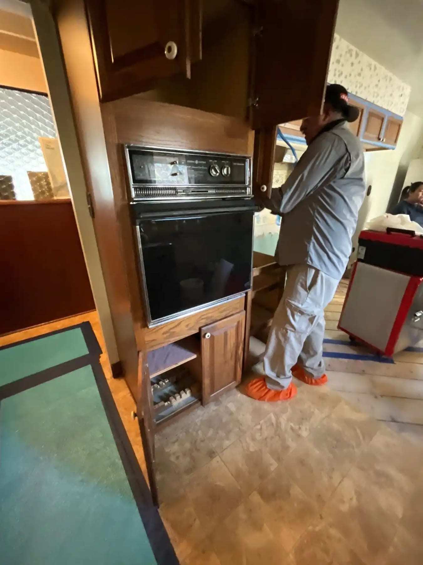 Technician cleaning the inside of a wall oven